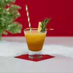 Blitzen Bourbon holiday slush mix pouch with cocktail glass by fireplace.