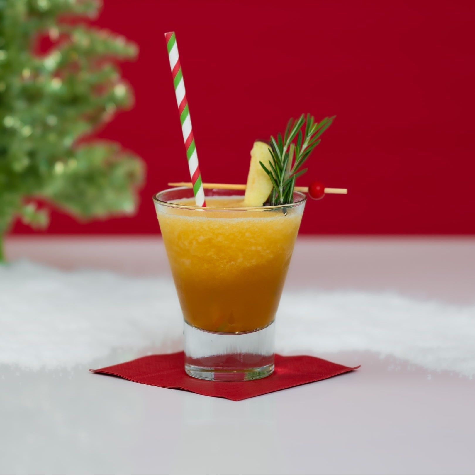 Blitzen Bourbon holiday slush mix pouch with cocktail glass by fireplace.