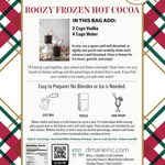 Boozy Frozen Hot Cocoa slush mix pouch with glass of frozen cocoa by fireplace and Christmas tree.