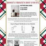 Boozy Frozen Hot Cocoa slush mix pouch with glass of frozen cocoa by fireplace and Christmas tree.