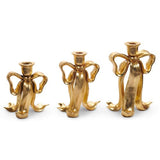 Set of three gold bow candlesticks in assorted heights, made of resin and iron, designed for taper candles.