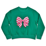 Green children’s sweatshirt with a large pink and white striped sequin bow on the front.
