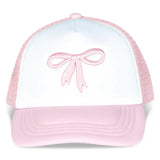 White and pink bow trucker hat with embroidered bow detail, mesh back, and adjustable strap.