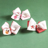 white hair bows with red polka dots on a green background