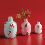 Light blue ceramic vase with red and white candy cane and peppermint accents.