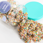 Colorful sprinkles in a container with a blue lid on a white background