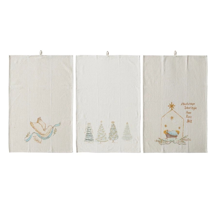 Set of 3 cotton holiday tea towels with printed designs: dove, trees, and nativity