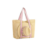 Beige straw tote bag with pink straps on a white background