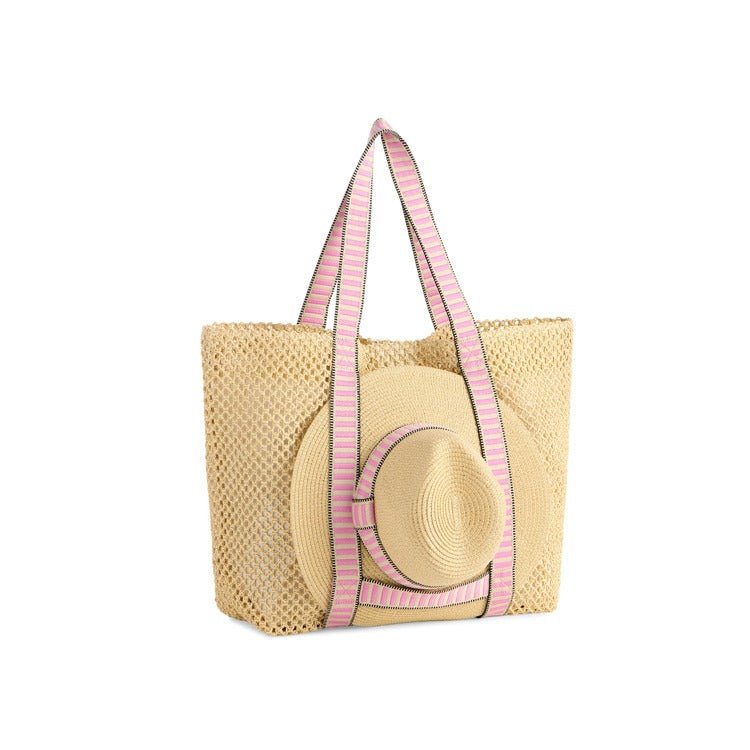 Beige straw tote bag with pink straps on a white background