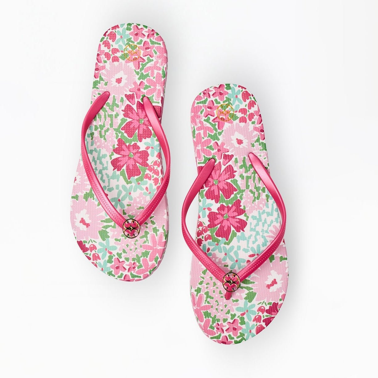 Pair of floral flip-flops with pink straps on a white background