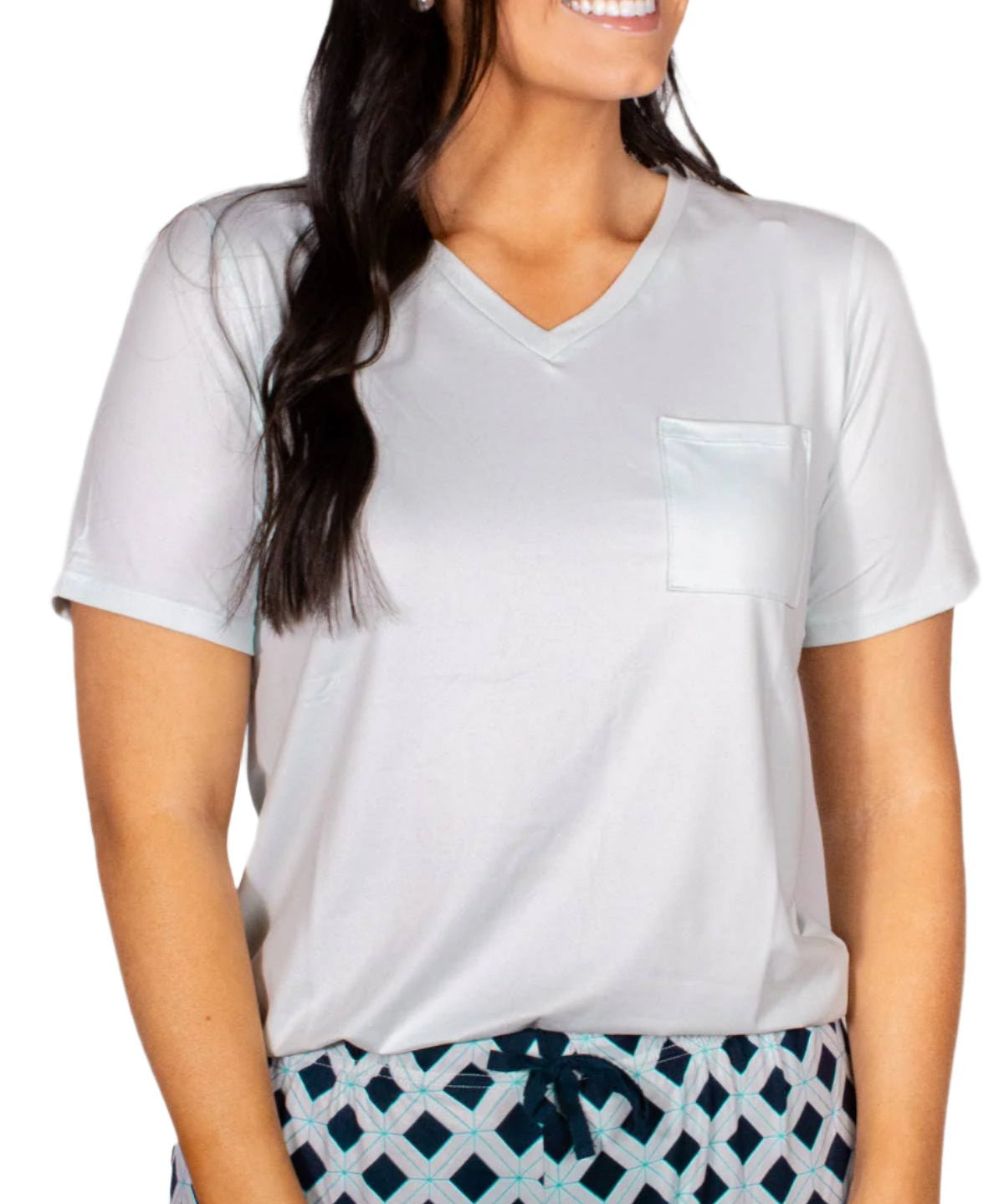 Woman wearing soft ice-colored v-neck tee with pocket and patterned drawstring pajama bottoms