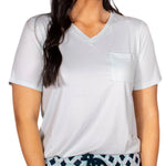 Woman wearing soft ice-colored v-neck tee with pocket and patterned drawstring pajama bottoms