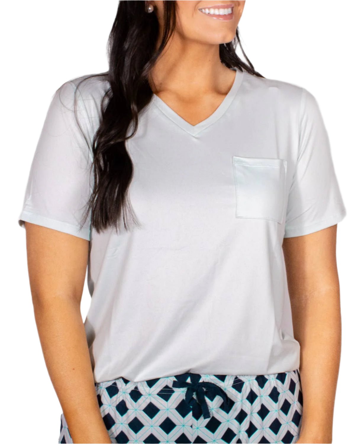 Woman wearing soft ice-colored v-neck tee with pocket and patterned drawstring pajama bottoms