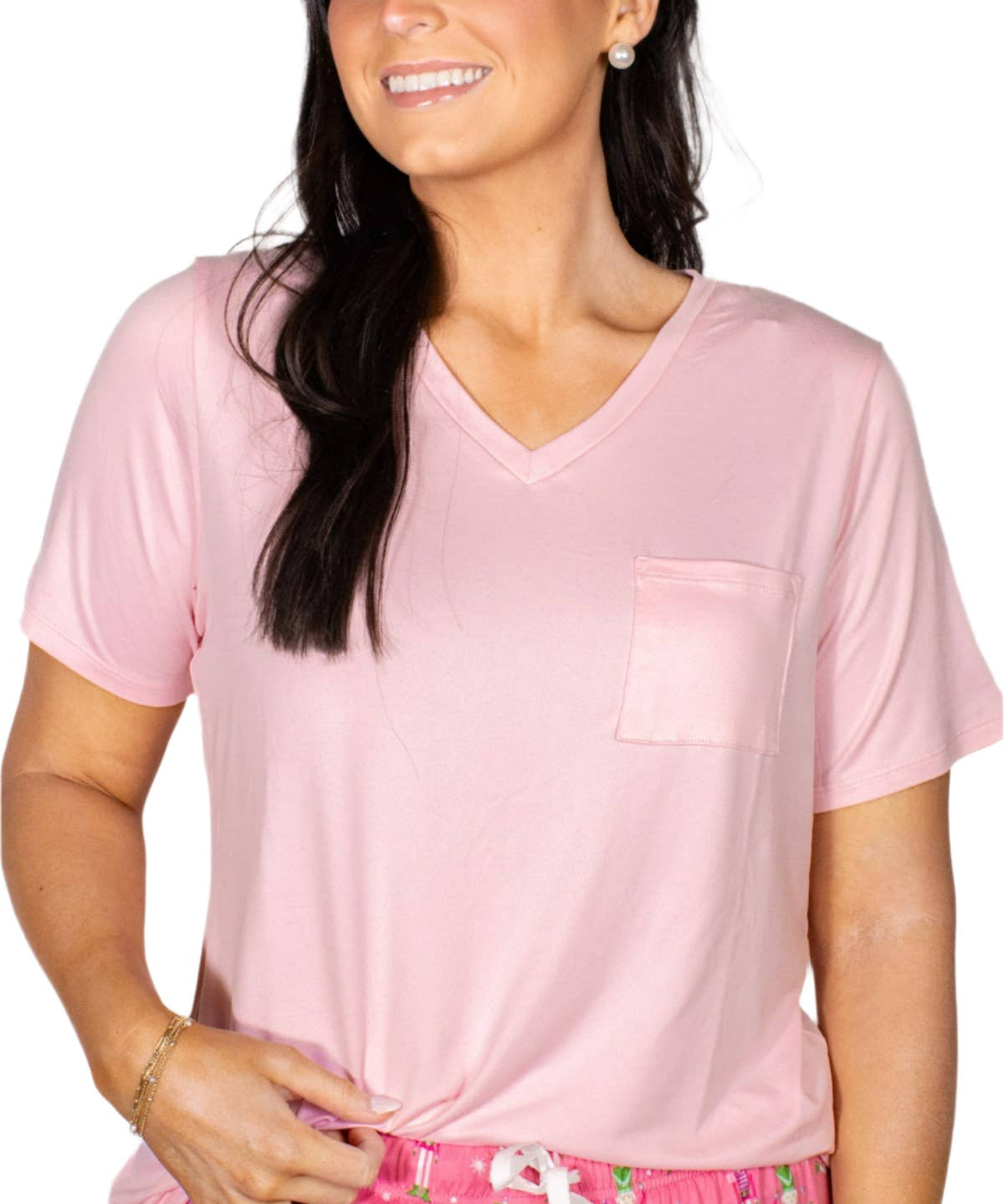 Woman wearing light pink v-neck pocket tee with printed pink pajama shorts