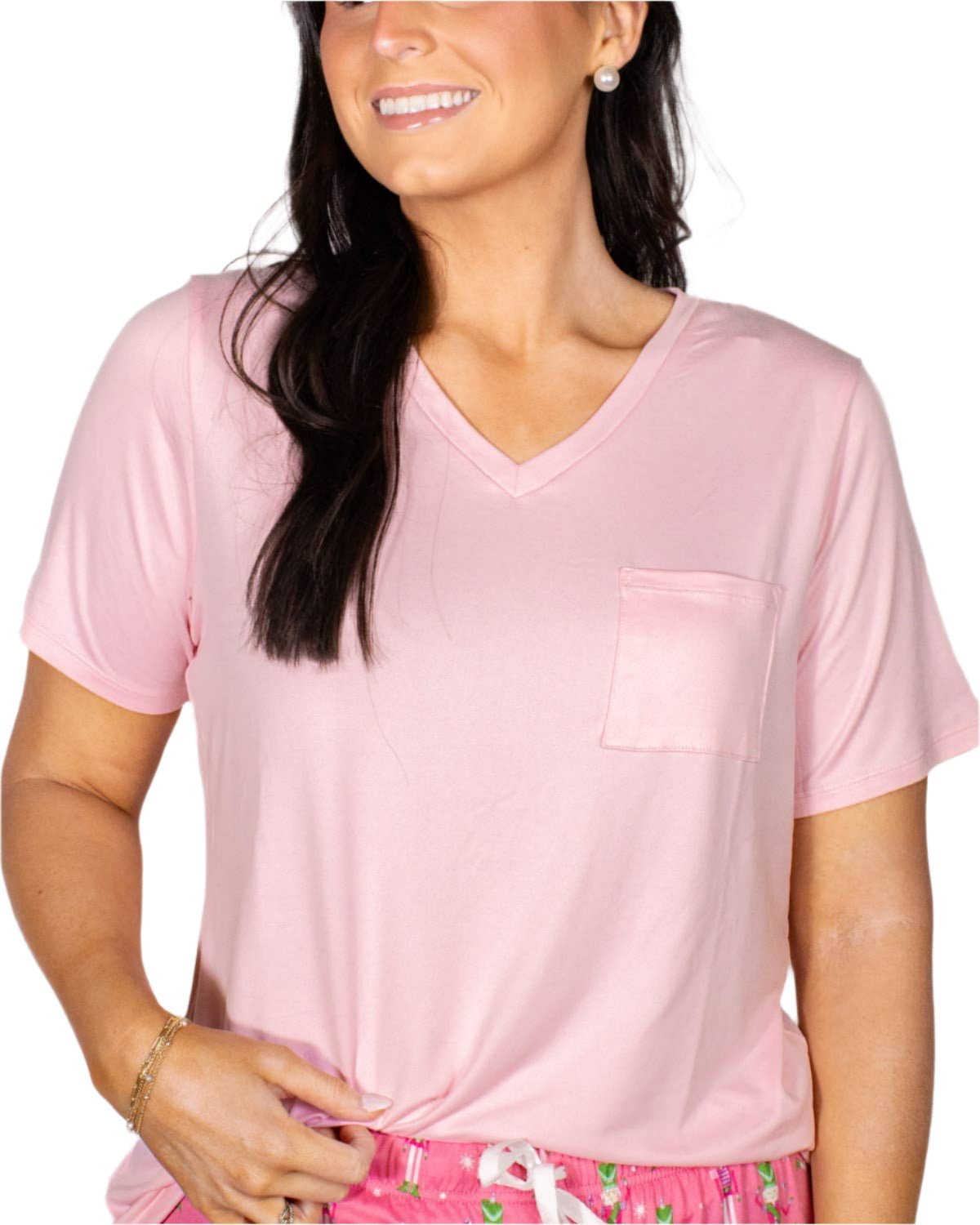 Woman wearing light pink v-neck pocket tee with printed pink pajama shorts