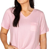 Woman wearing light pink v-neck pocket tee with printed pink pajama shorts