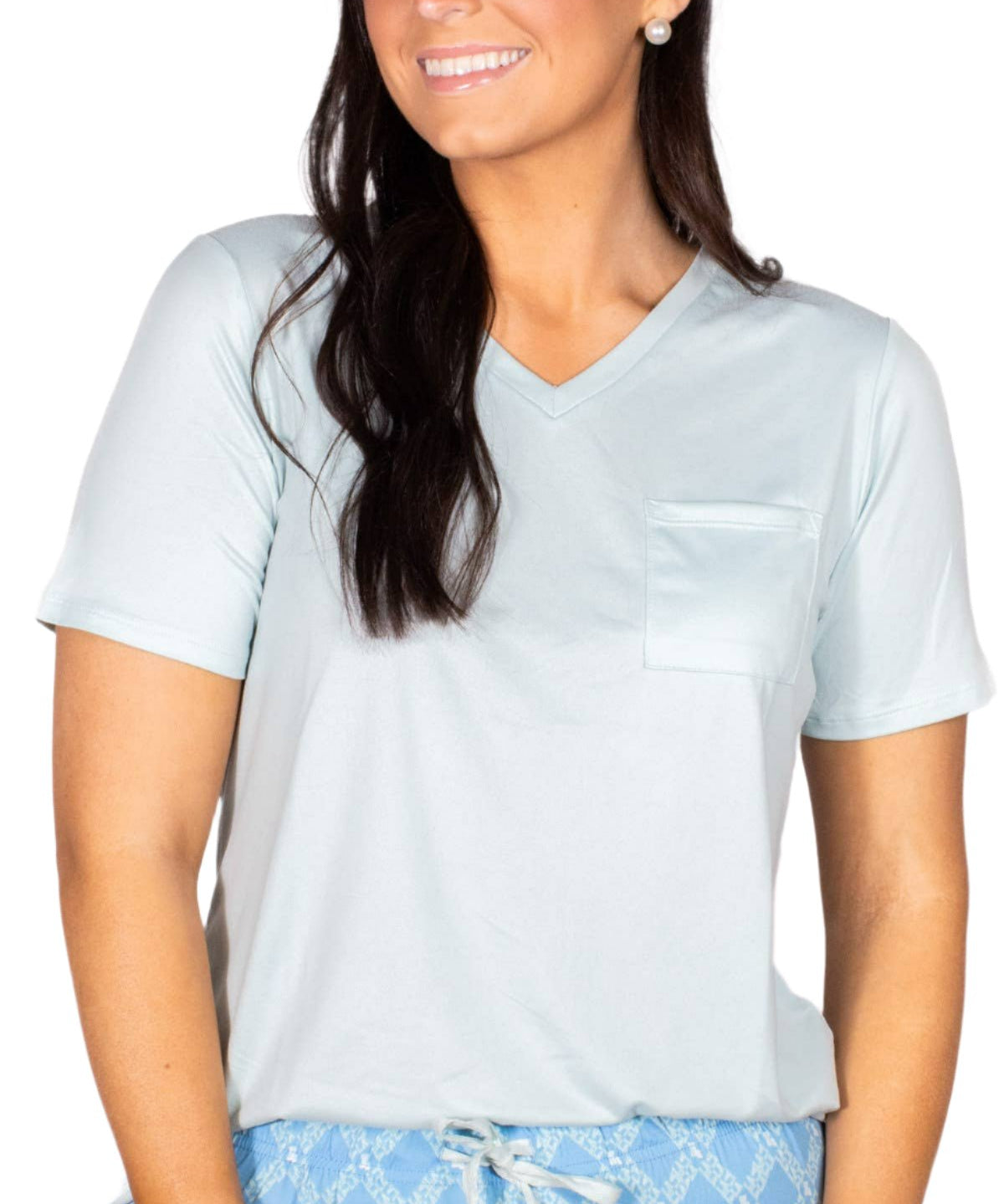 Woman wearing pale blue v-neck sleep tee with pocket and printed pajama bottoms