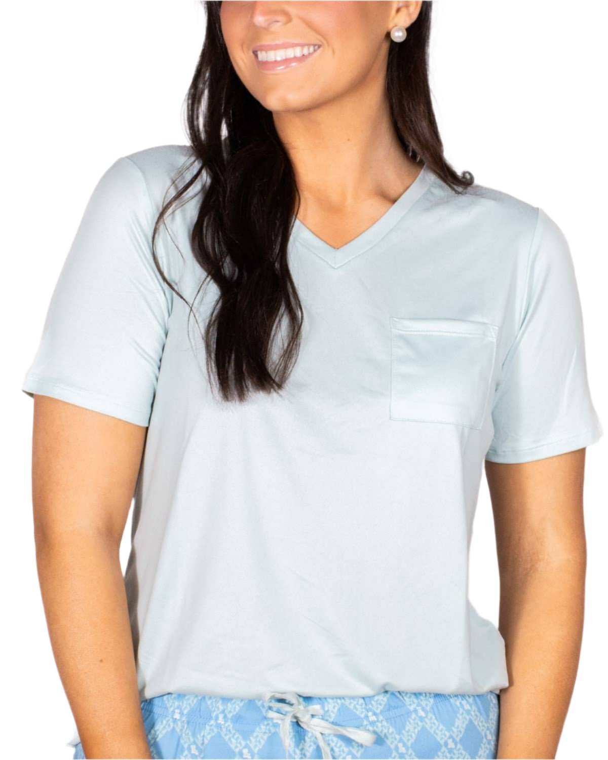 Woman wearing pale blue v-neck sleep tee with pocket and printed pajama bottoms