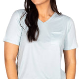 Woman wearing pale blue v-neck sleep tee with pocket and printed pajama bottoms