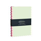 Scallop-shaped cream notepad with pink edge-painted sides, 160 tear-off blank pages, wrapped in black belly band by Idlewild Co.