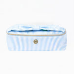 Blue and white striped toiletry bag with gold zipper on a white background