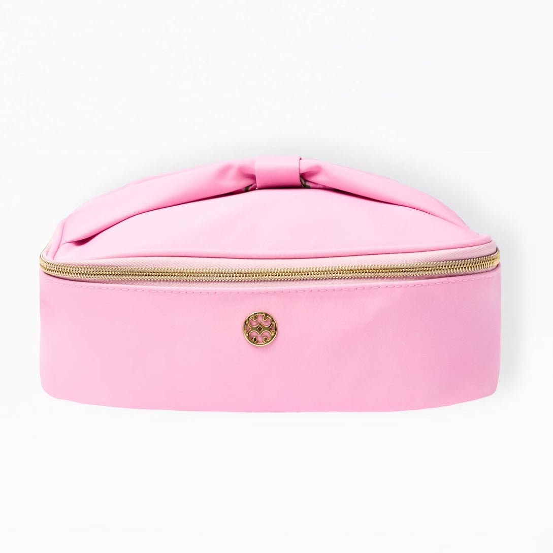 Pink cosmetic case with a bow on a white background