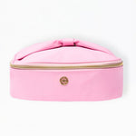 Pink cosmetic case with a bow on a white background