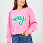 Pink sweatshirt with bold green chenille lettering that says “Merry,” puff sleeves