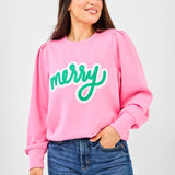 Pink sweatshirt with bold green chenille lettering that says “Merry,” puff sleeves