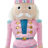 Pink Nutcracker plush ornament with faux fur, fleece, metallic embroidery, and hanging loop, measuring 7 inches tall.