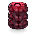 Pomme Rouge candle in red bubbled glass vessel with grape, clove, and ginger fragrance