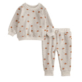 Children's outfit with sweatshirt and pants featuring pumpkin pattern on a white background