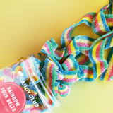Colorful gummy belts from Candy Club on a yellow background