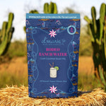d'marie Rodeo Ranch Water packaging on a hay bale with cacti in the background