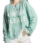 Model wearing mint green “Mimosa Please” oversized sweatshirt with vintage wash and bold white lettering