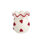 White ceramic vase with raised red hearts and scalloped ruffle edge.