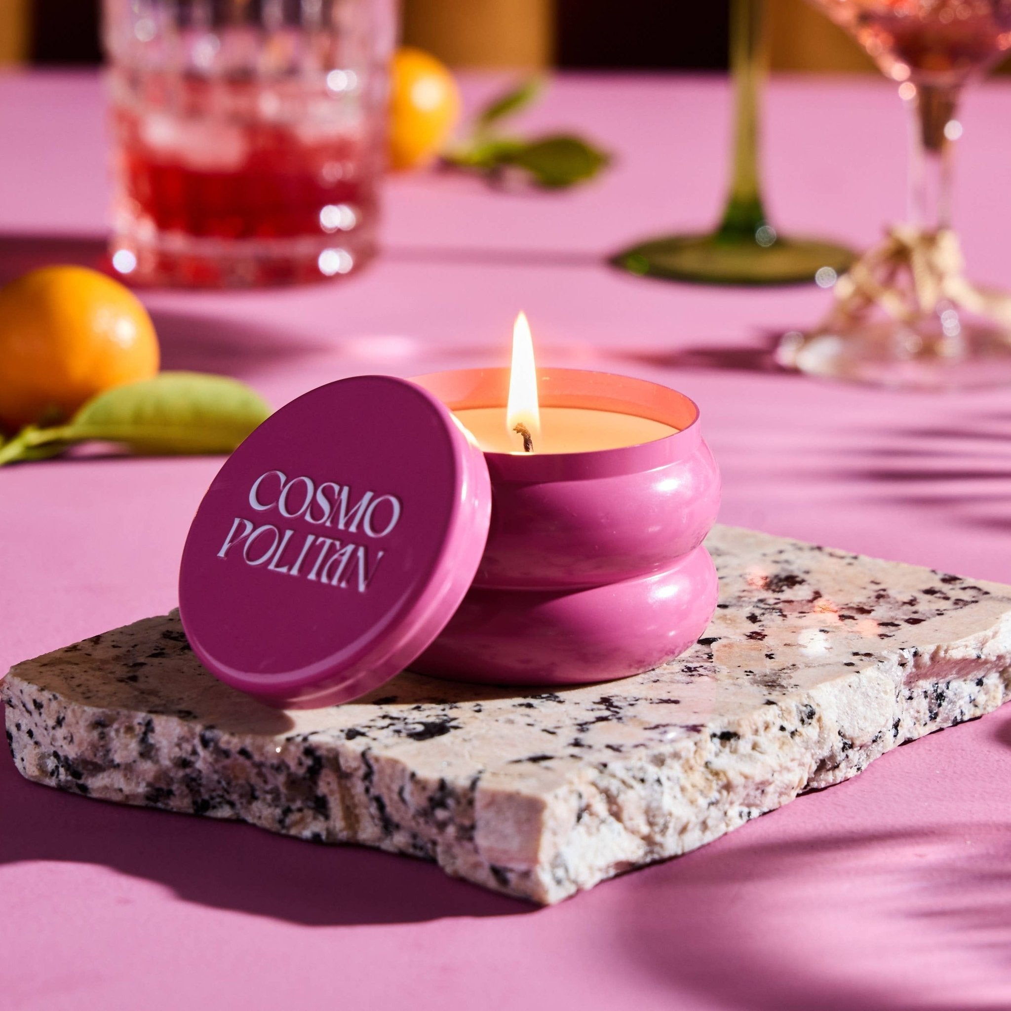 Cosmopolitan candle in cranberry-pink sculptural tin with flame