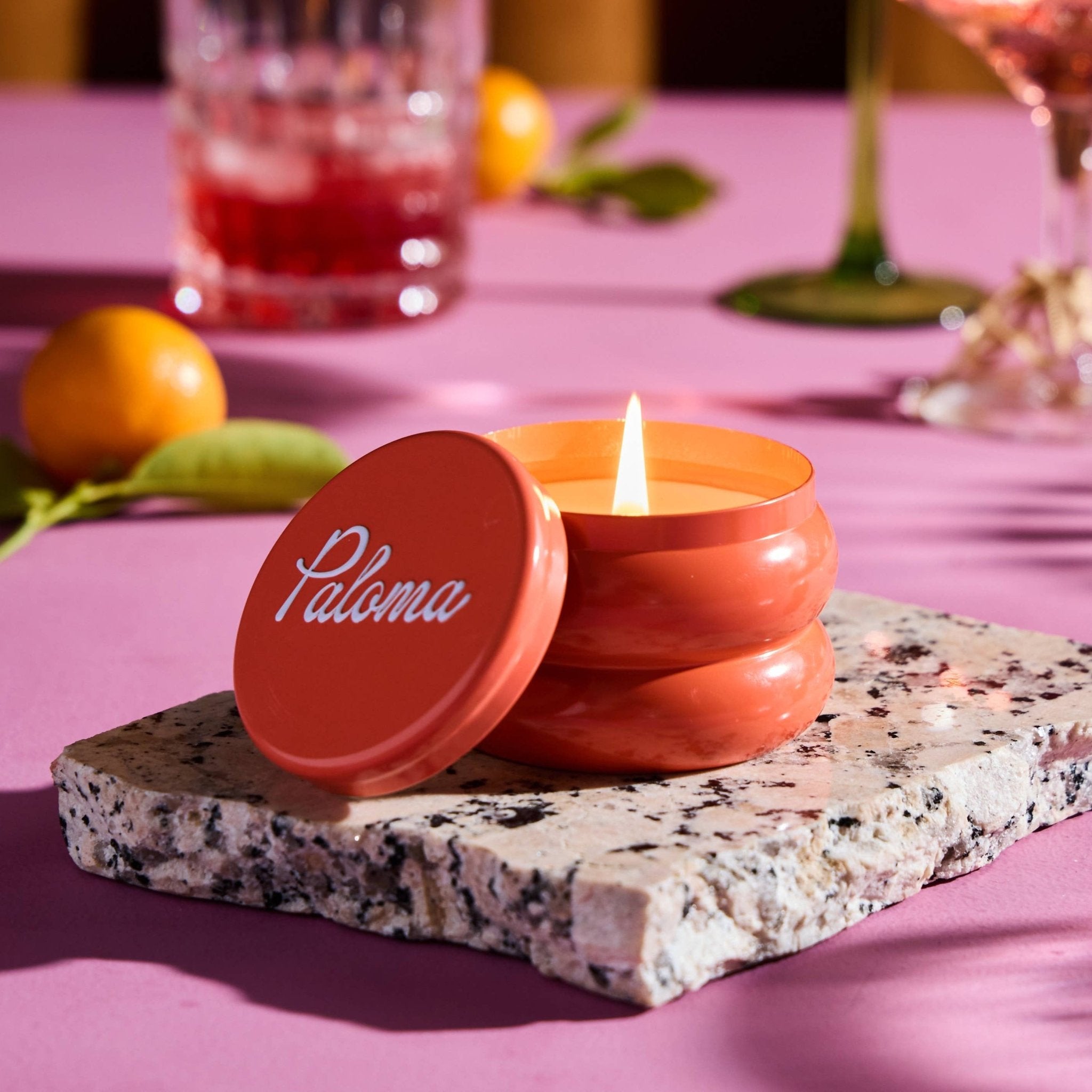Paloma candle in sculptural peach-colored tin with flame