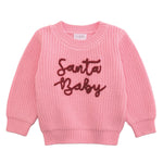 Pink sweater with 'Santa Baby' text on a white background