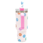 White insulated travel cup with colorful smiley faces, pink handle, and straw with topper