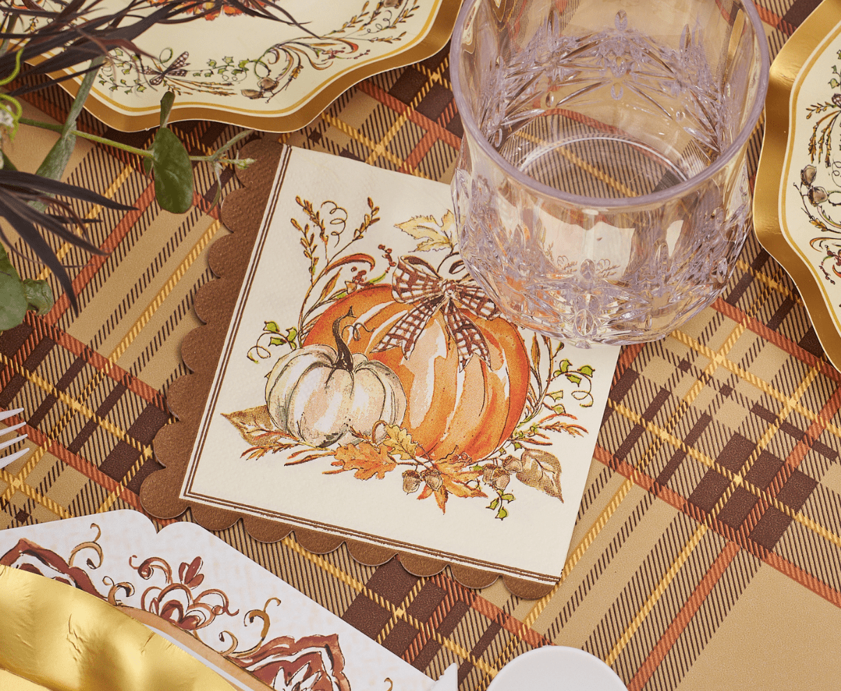 Fall-themed scalloped cocktail napkin with illustrated pumpkins and gingham bow