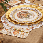 Decorative Thanksgiving table setting with gold charger, plate, and napkins on a checkered tablecloth.