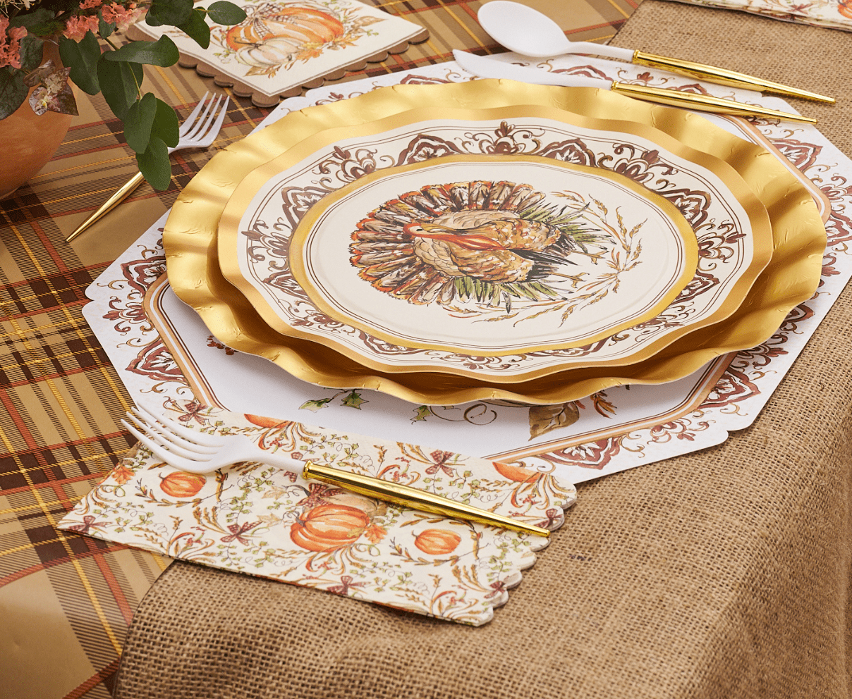 Decorative Thanksgiving table setting with gold charger, plate, and napkins on a checkered tablecloth.