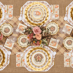 Decorative table setting with patterned plates, napkins, and a floral centerpiece on a checkered tablecloth.