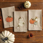 Chambray hand towel with three embroidered pumpkins and French knot detail