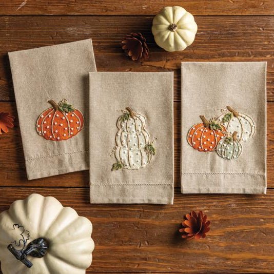Chambray hand towel with three embroidered pumpkins and French knot detail