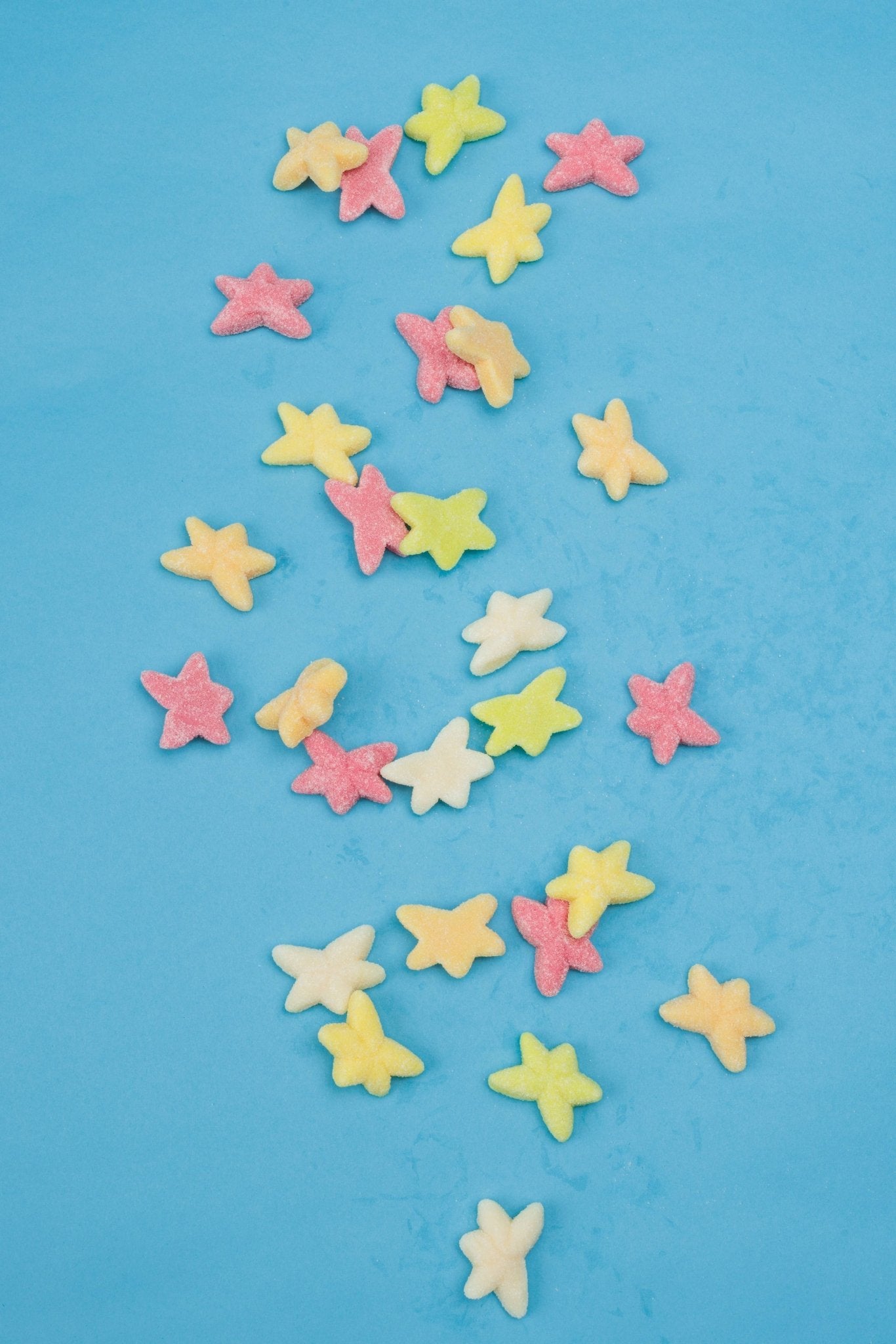 Colorful star-shaped candies on a blue background