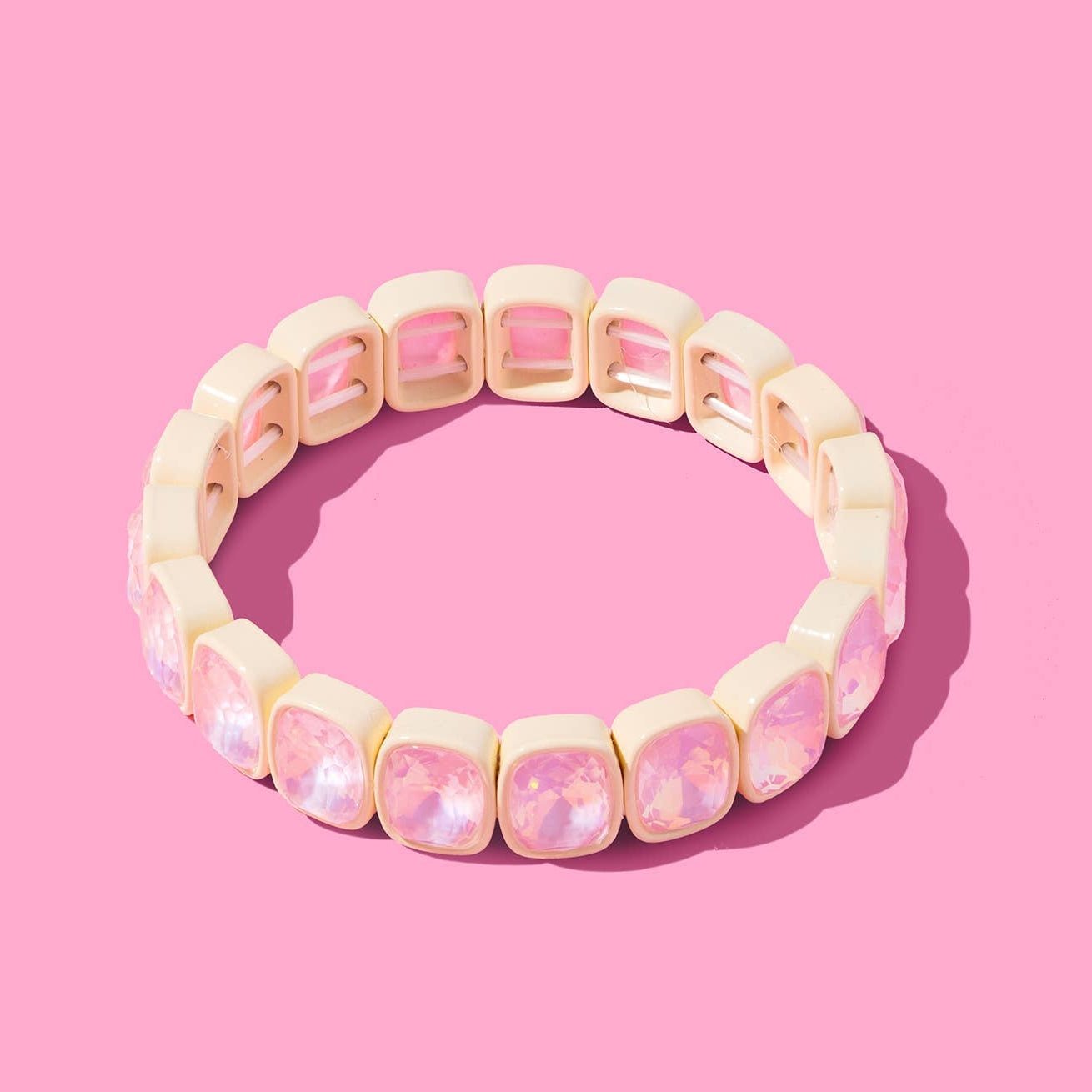 Beige bracelet with pink accents on a pink background