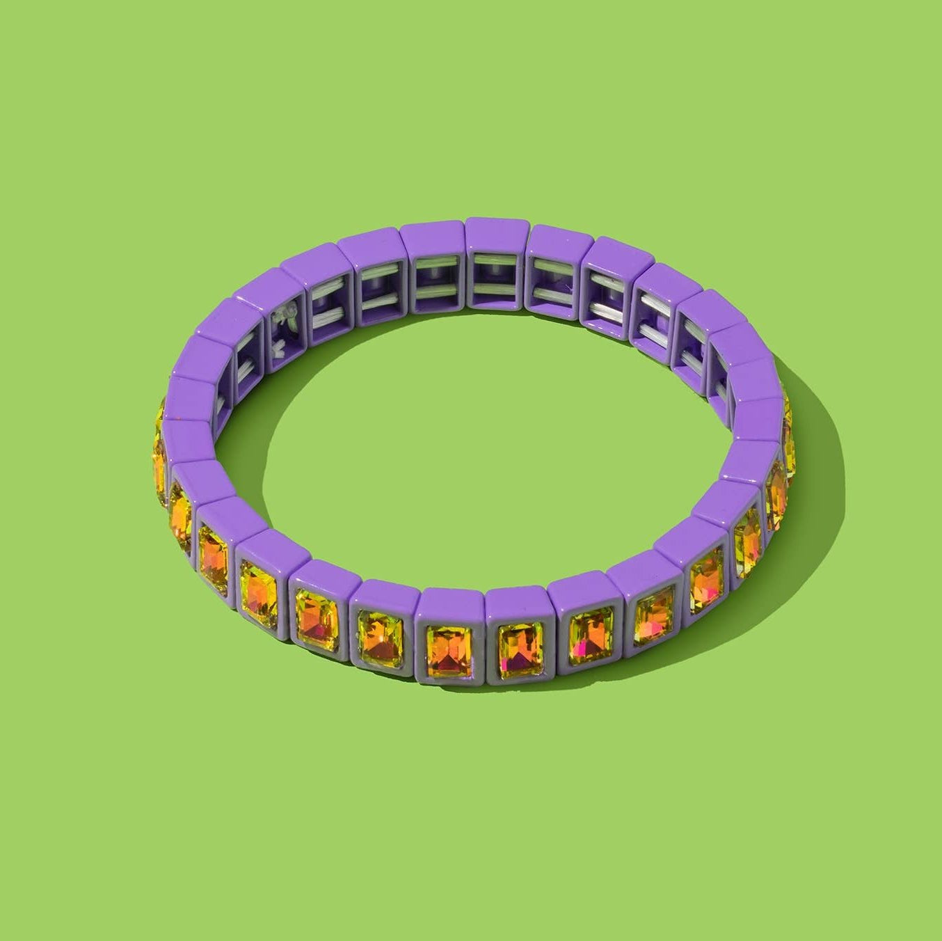 Bracelet with purple band and multicolored stones on a green background