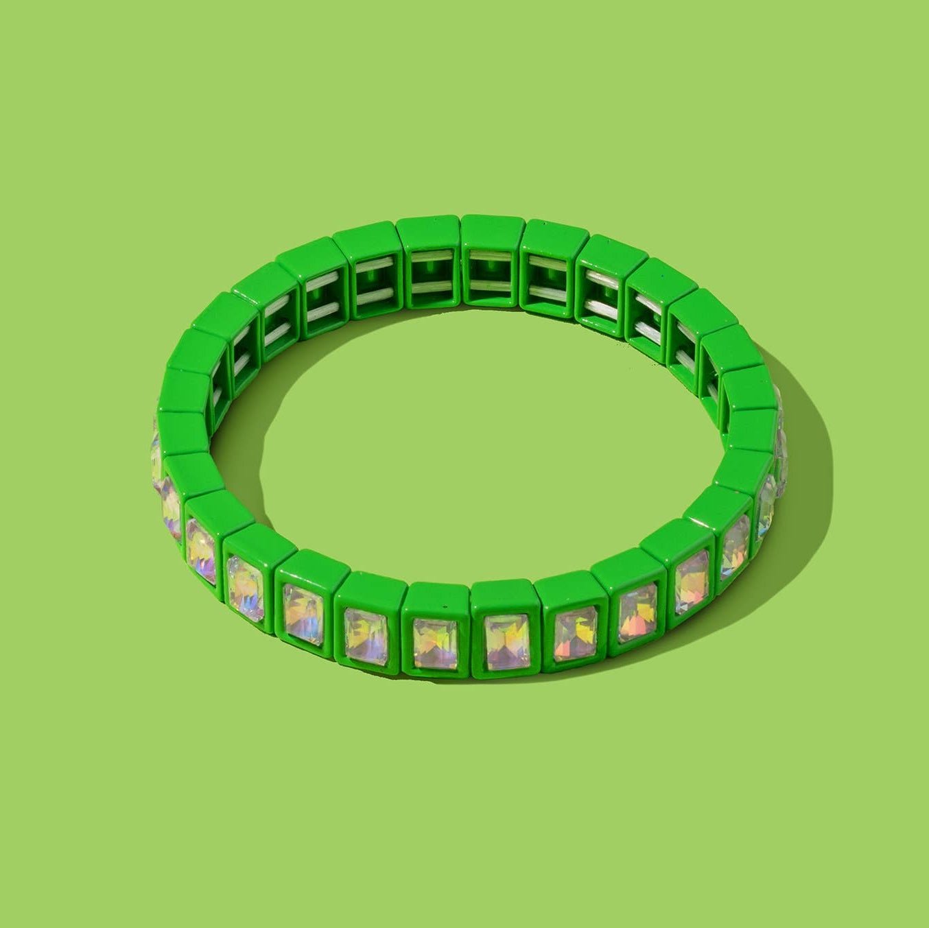 Green bracelet with small square charms on a green background